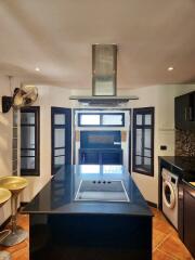 Modern kitchen with black countertops and stainless steel appliances