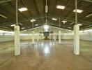 Spacious empty industrial building interior with overhead lighting