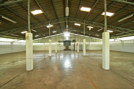 Spacious empty industrial building interior with overhead lighting