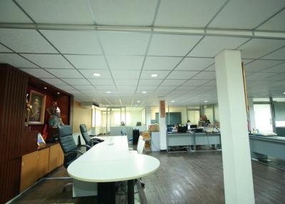 Spacious open-plan office interior with workstations and bright lighting