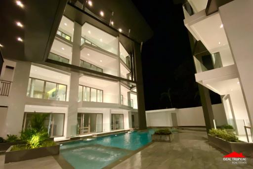 Exterior view of a modern two-story house with pool at night