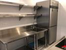 Modern stainless steel commercial kitchen with large refrigerator