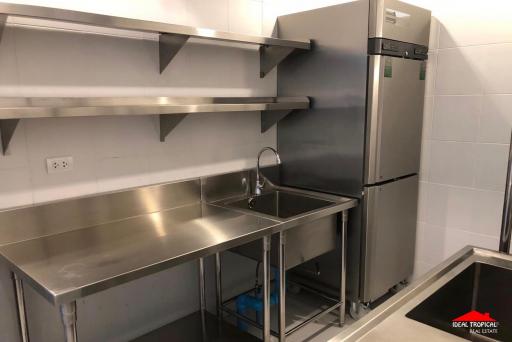 Modern stainless steel commercial kitchen with large refrigerator