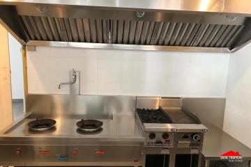 Commercial kitchen with stainless steel appliances and exhaust hood