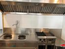Commercial kitchen with stainless steel appliances and exhaust hood