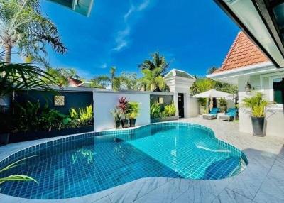 Luxurious outdoor pool with tropical landscaping and clear blue water