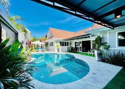 Bright and inviting outdoor pool area with a patio and lush landscaping