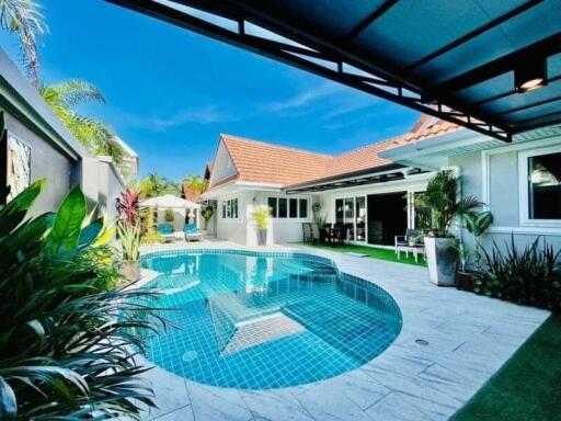 Bright and inviting outdoor pool area with a patio and lush landscaping