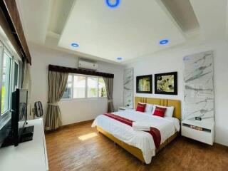 Spacious bedroom with modern design, large bed, and ample lighting