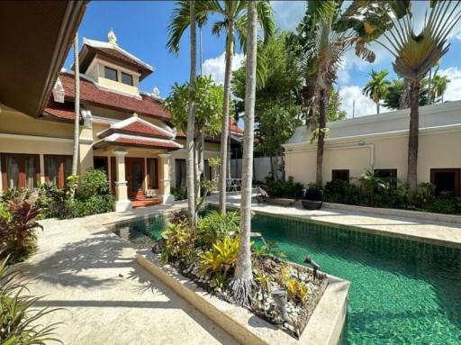 Luxury villa exterior with swimming pool and lush garden