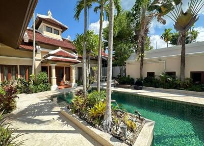 Luxury villa exterior with swimming pool and lush garden