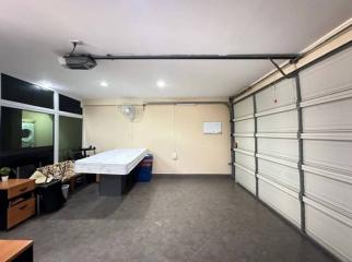 Spacious garage with tiled floor and storage cabinets