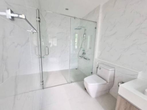 Modern bathroom with glass shower enclosure and marble tiles
