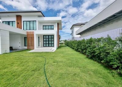 Modern white residential house with green lawn and blue sky