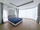 Spacious modern bedroom with large windows and hardwood flooring