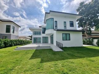 Modern two-story house with a well-manicured lawn and clear blue skies