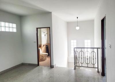 Spacious unfurnished building with open entryway, visible bathroom, and balcony