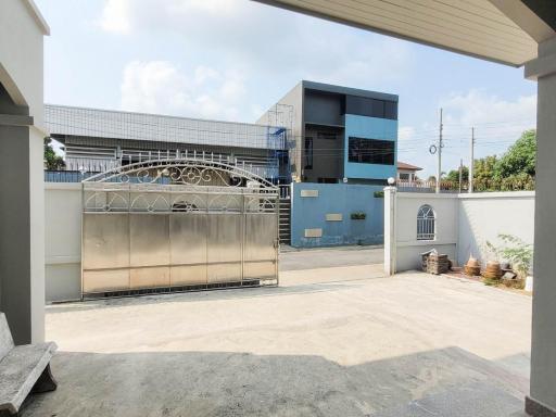 Exterior view of a modern two-storey building with a spacious gated driveway