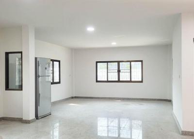 Spacious and bright empty interior of a property showing shiny tiled flooring and multiple windows