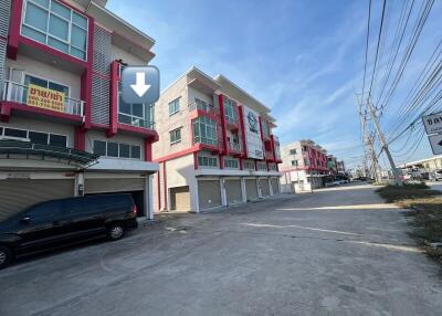 Modern residential townhouses with red accents and ample parking space