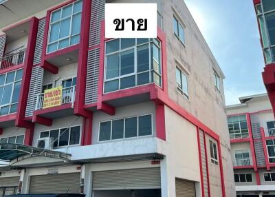 Contemporary two-story building with red accents and private parking spaces