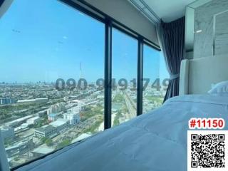 Spacious bedroom with large windows offering a panoramic city view