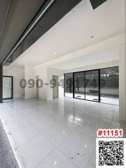 Spacious unfurnished building interior with large windows and glossy tiled flooring