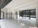 Spacious unfurnished building interior with large windows and glossy tiled flooring