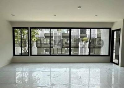 Spacious unfurnished living room with large windows and glossy tiled floor