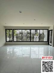 Spacious unfurnished living room with large windows and glossy tiled floor