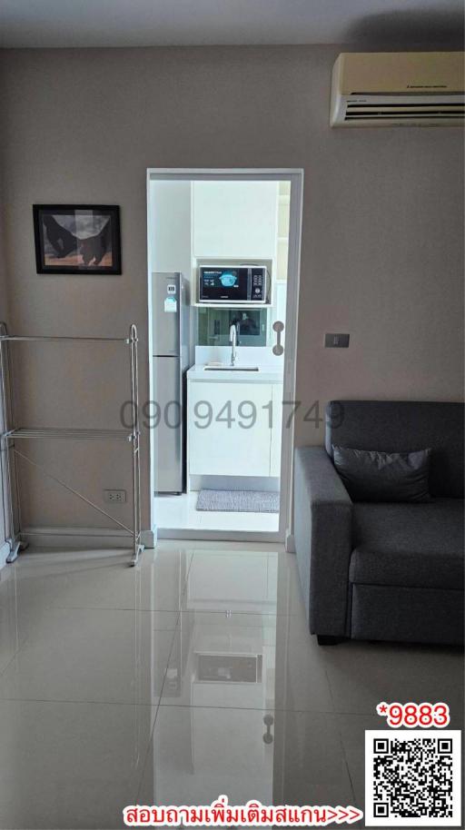 Modern living area with open doorway to kitchen and sleek furnishings