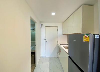 Compact modern kitchen with white cabinetry and marble flooring