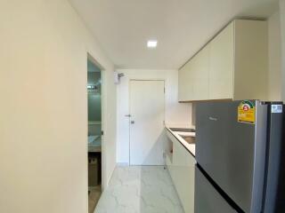 Compact modern kitchen with white cabinetry and marble flooring