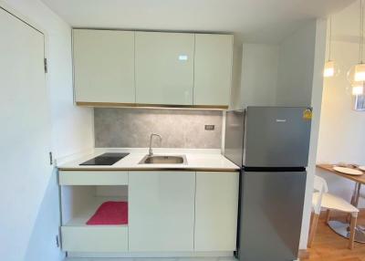 Compact modern kitchen with white cabinets and stainless steel appliances