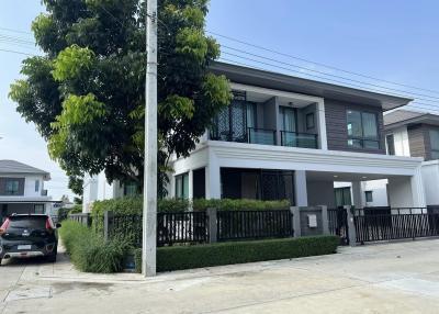 Modern two-story house with a gray and white exterior and a well-manicured front lawn