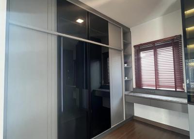 Modern bedroom with large built-in wardrobe and a window with blinds