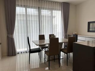 Modern dining room with large window and elegant curtains