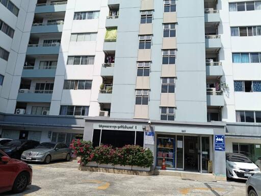 Exterior view of a modern apartment building with parking spaces