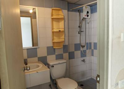 Compact bathroom with white and blue tile decor