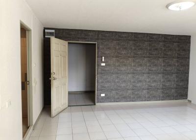 Spacious interior room with tiled flooring and dark accent wall
