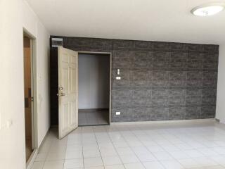 Spacious interior room with tiled flooring and dark accent wall