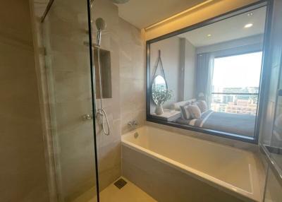 Modern bathroom with glass shower and view into bedroom and balcony