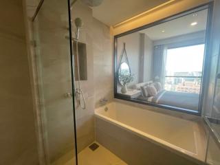 Modern bathroom with glass shower and view into bedroom and balcony