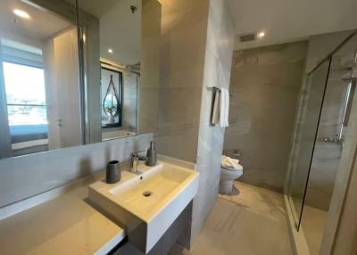 Modern bathroom with glass shower and grey tiling