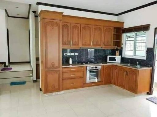 Spacious modern kitchen with wooden cabinets and built-in appliances