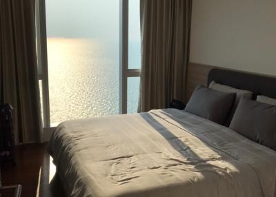 Modern bedroom with large windows overlooking the ocean