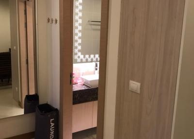 Modern bathroom with illuminated vanity mirror and adjoining laundry area