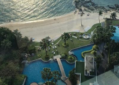Aerial view of a coastal resort complex with swimming pool and beachfront