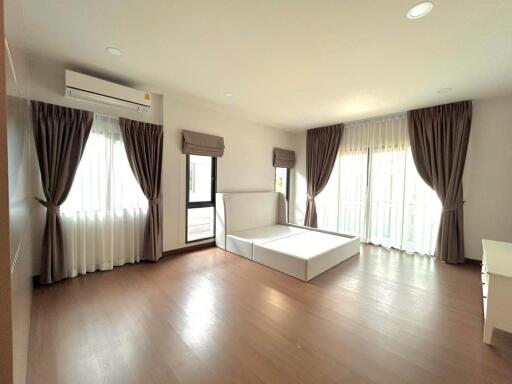 Spacious bedroom with hardwood floors and large windows