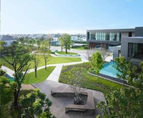 Lush outdoor communal space with a swimming pool and walking paths